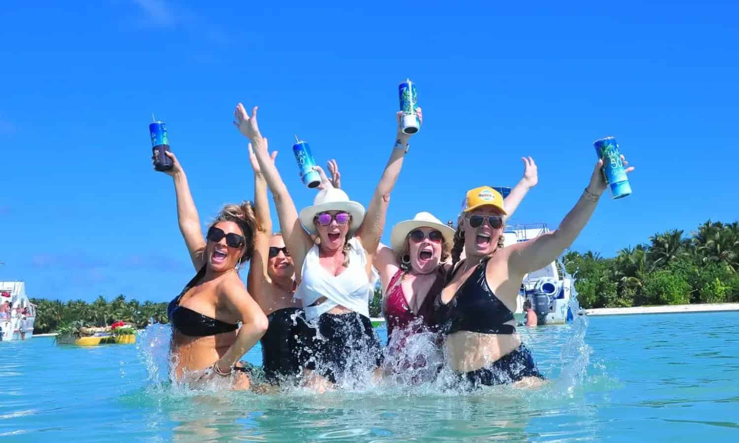Punta Cana Group of women celebrating with drinks in the ocean during a Punta Cana boat excursion.