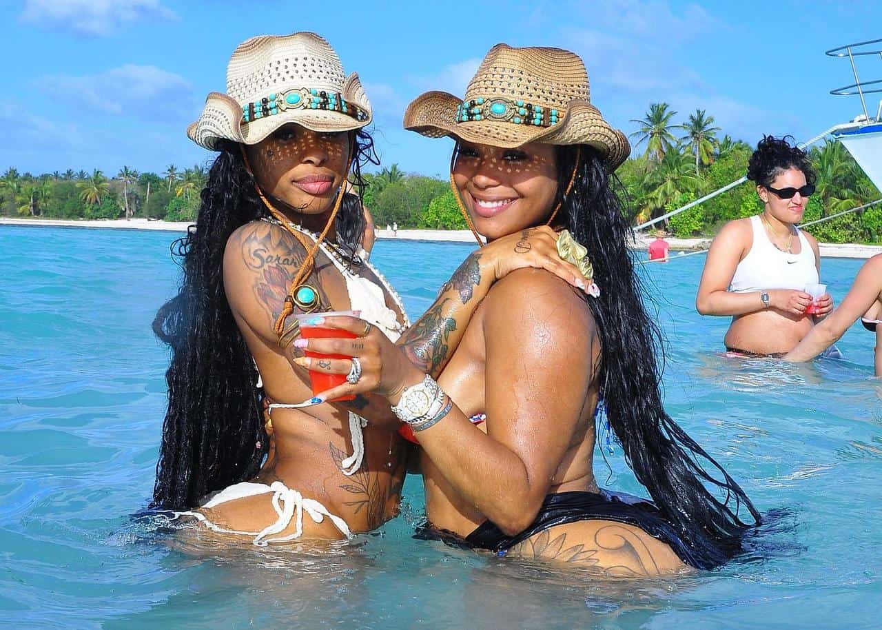 Punta Cana Two women in swimsuits and hats having fun in clear Punta Cana waters.