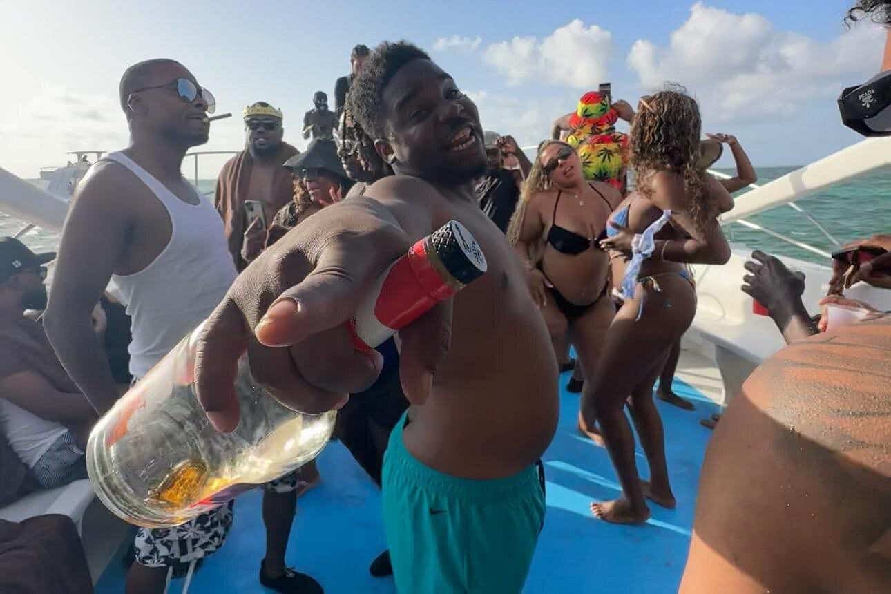 Punta Cana Group of people enjoying a lively party on a boat in Punta Cana with drinks and dancing.