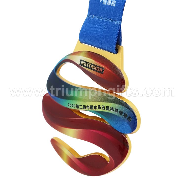 Shiny metallic ribbon award medal with other colors and an attached blue lanyard, custom-designed for sports or corporate events, featuring engraved text.