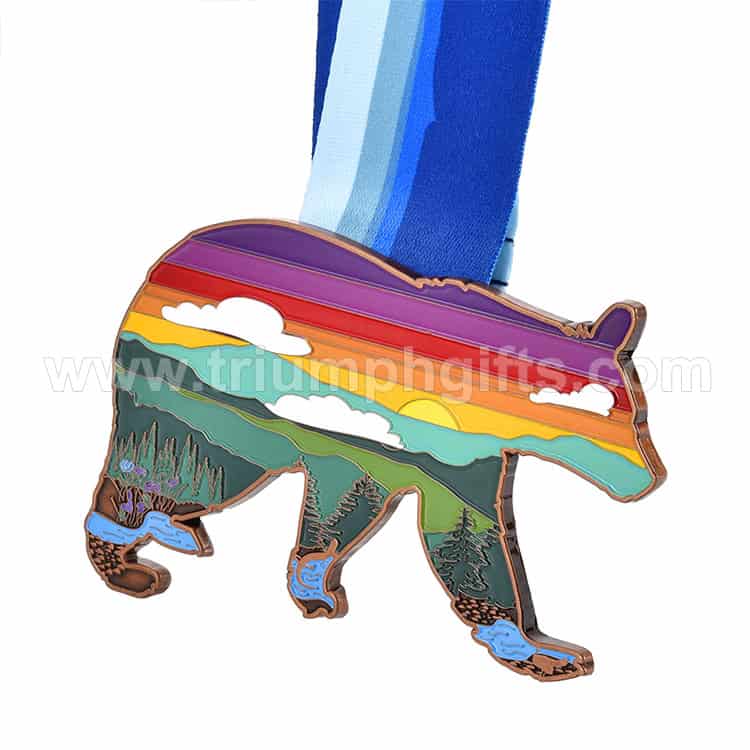 Colorful wilderness-themed medallion featuring a nature landscape with mountains, rivers, trees, and a sunset, designed as a ceremonial award or trophy with a blue ribbon.