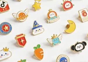 Colorful enamel pins featuring various playful designs and characters.