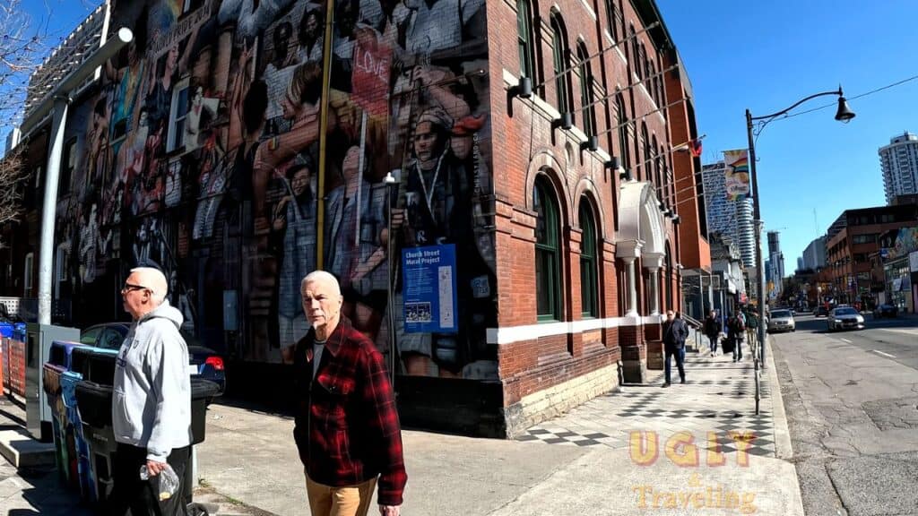 Vibrant city street scene with murals, pedestrians, and urban architecture in downtown.