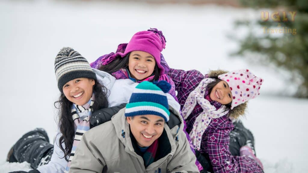 Families enjoying snow activities in winter, outdoor travel in snowy landscape, group of smiling children and adults in colorful winter gear for travel blog.