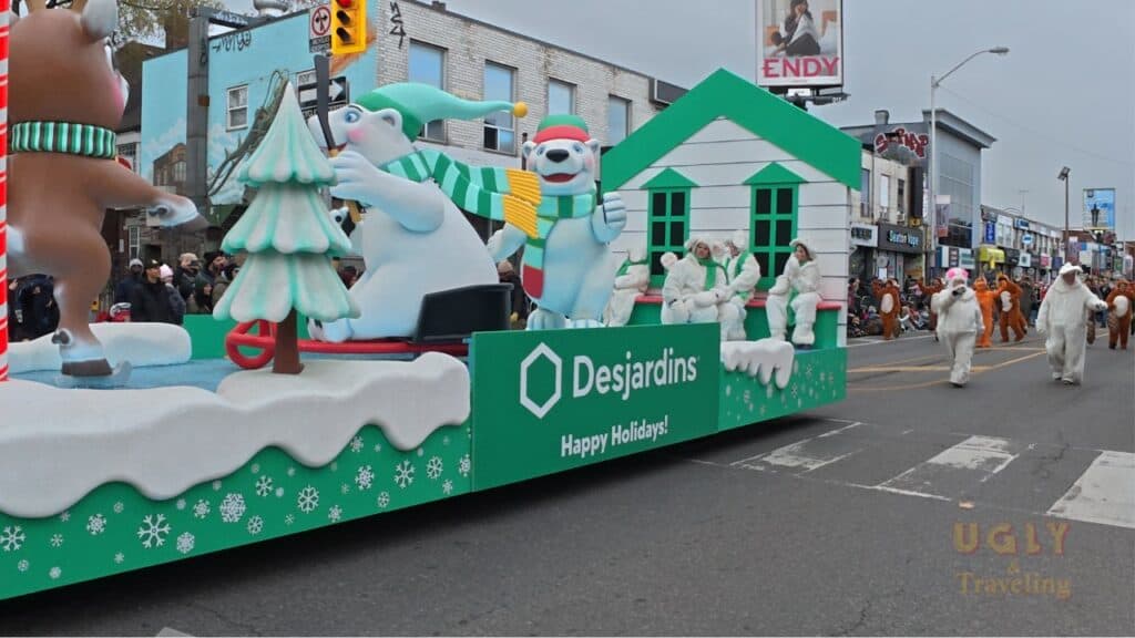 Colorful holiday parade float with animated snowmen and polar bears, promotes Desjardins, festive street scene, winter holiday celebration.