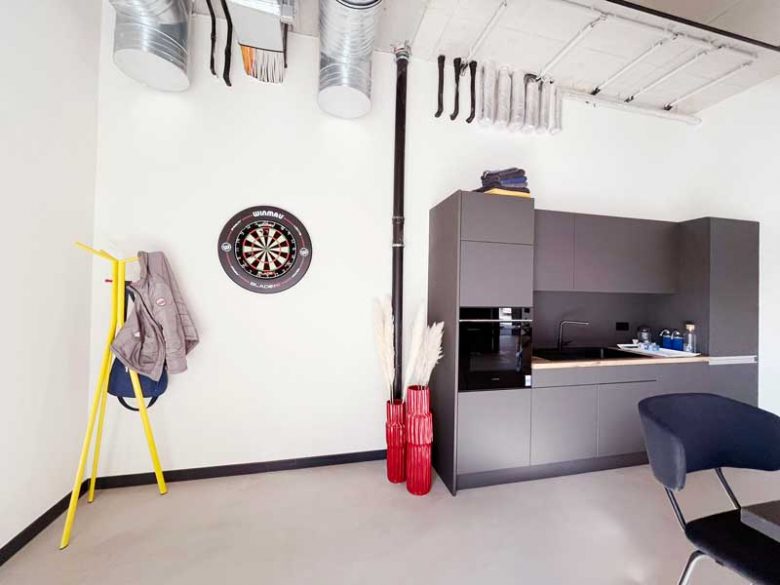 Pausenraum mit Küche, gemütlichen Sitzmöglichkeiten und stilvoller Beleuchtung