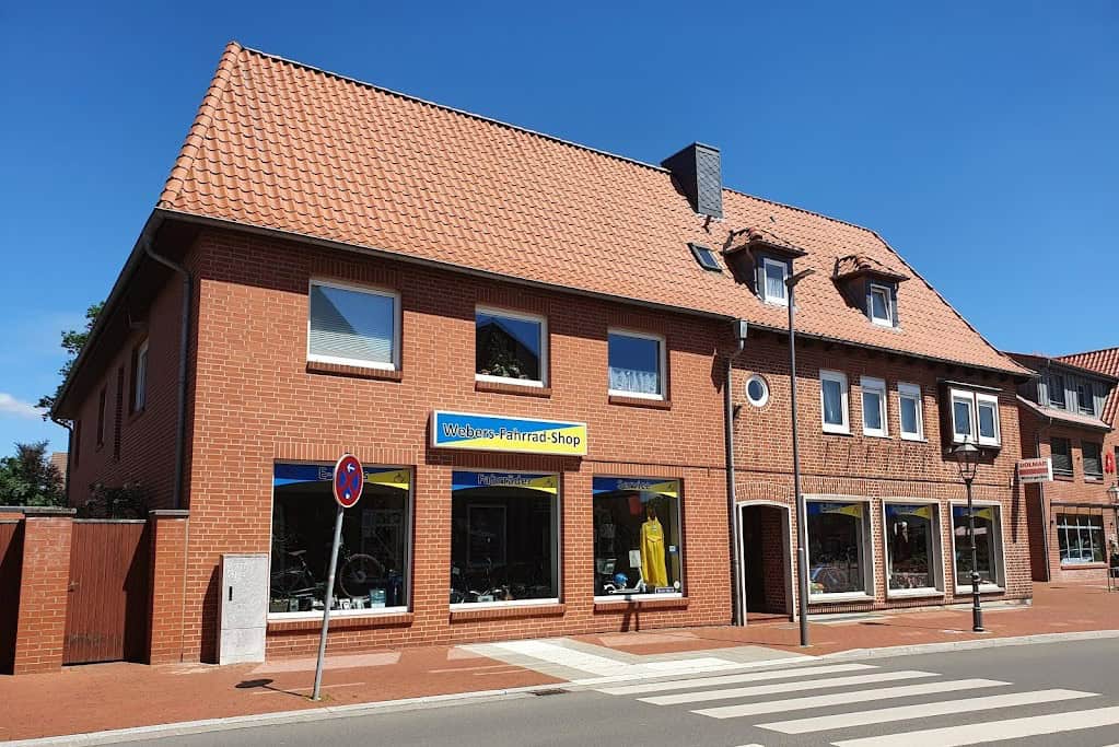 Webers Fahrradshop in Bleckede mit rotem Ziegeldach und großen Schaufenstern.