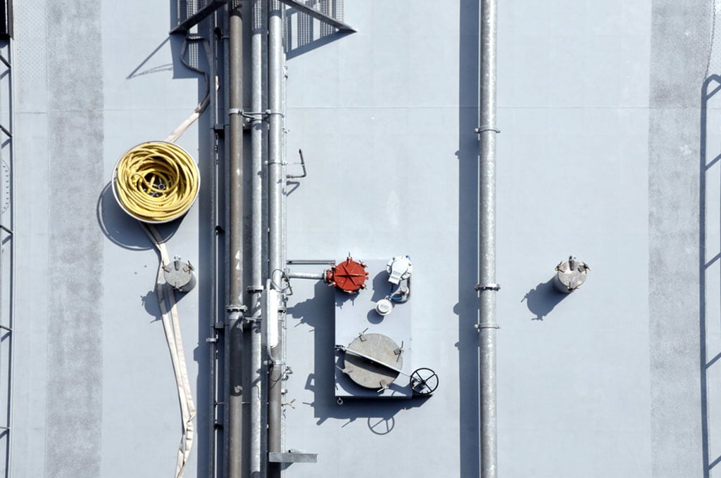 Hochdruckgasrohre und Industrieanlagen an einer Gebäudeaußenwand.