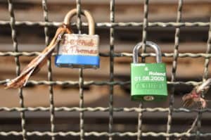 Vorhängeschlösser an einem Gitter, symbolisieren Liebe und Verbundenheit, ideal für romantische Orte.
