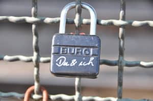 Schloss mit Aufschrift "Du & ich" an einem Gitternetz, Symbol für Vertrauen und Liebe, romantisches Motiv.