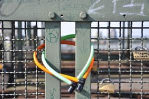 Liebesherz aus Neon auf Brückengeländer mit Schloss – Symbol der ewigen Liebe.