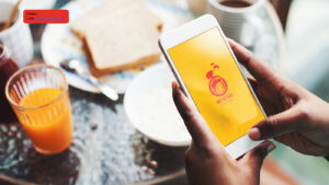 Imagem de uma pessoa segurando um smartphone com um aplicativo no café.