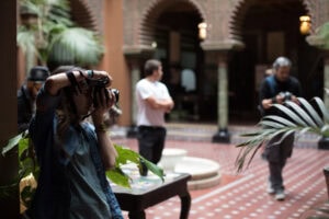 Imagem de estudantes e profissionais em ambiente educacional do World Academy, focados em projetos de fotografia.