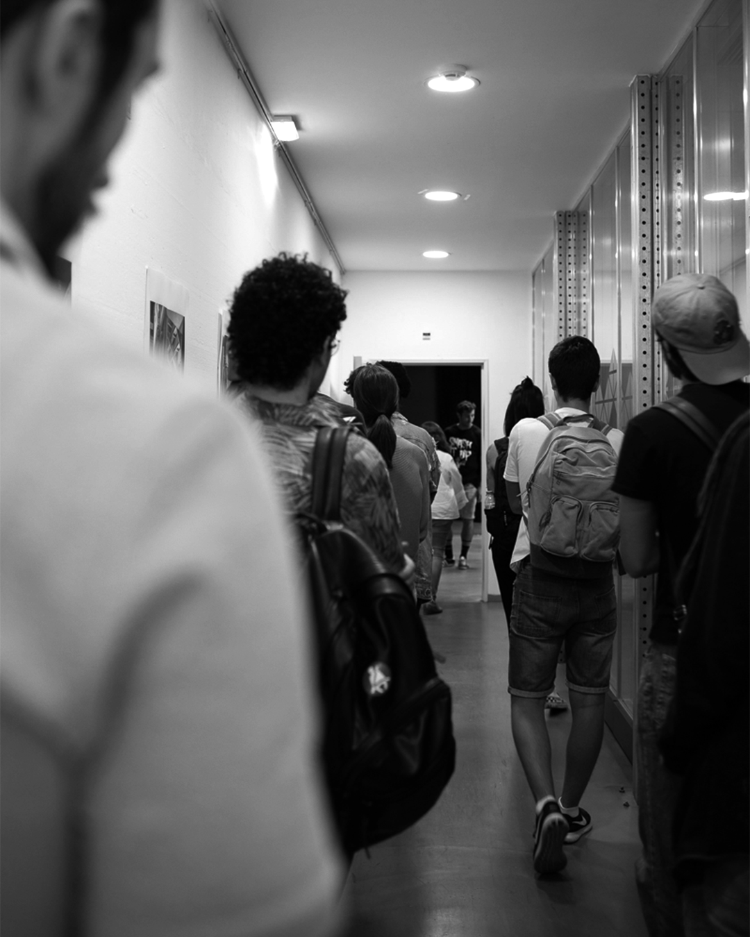 Estudantes em fila na escola, aguardando ingresso para aulas ou atividades educativas.