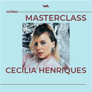 Imagem de uma mulher durante uma masterclass de atuação com fundo de decoração metálica brilhante.