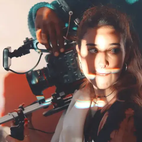Fotógrafo ajustando câmera para filmagem de alta qualidade com iluminação natural.