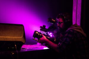 Cineasta a trabalhar com câmera profissional em ambiente de estúdio.