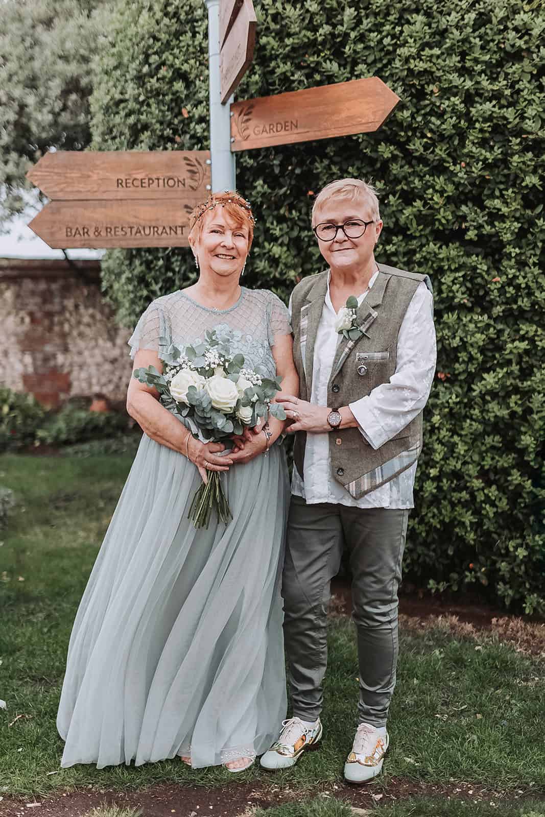 LGBTQ couple portrait in coastal gardens at Titchwell Manor – Norfolk wedding photographer
