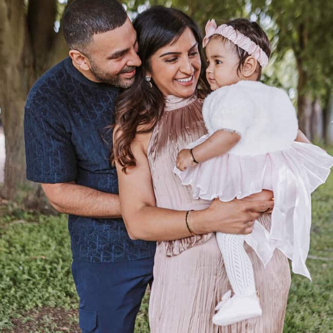 Peterborough 1st birthday photographer capturing Hemal and Roshni with their daughter Amaeya at Bedford Hall outdoors