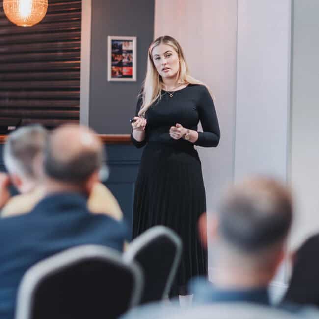 Corporate event photographer UK capturing Ella Hardy speaking at Land Profits event Hilton Stoke-on-Trent