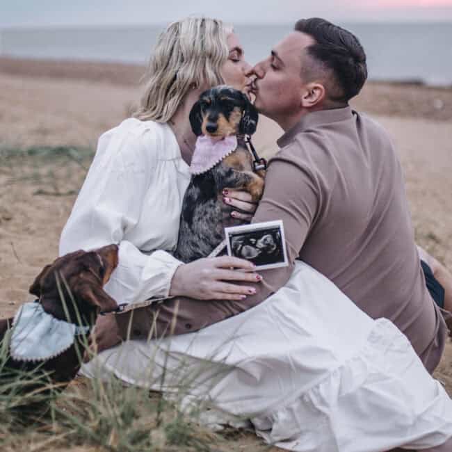 couple kissing with their dogs - hunstanton maternity photographer
