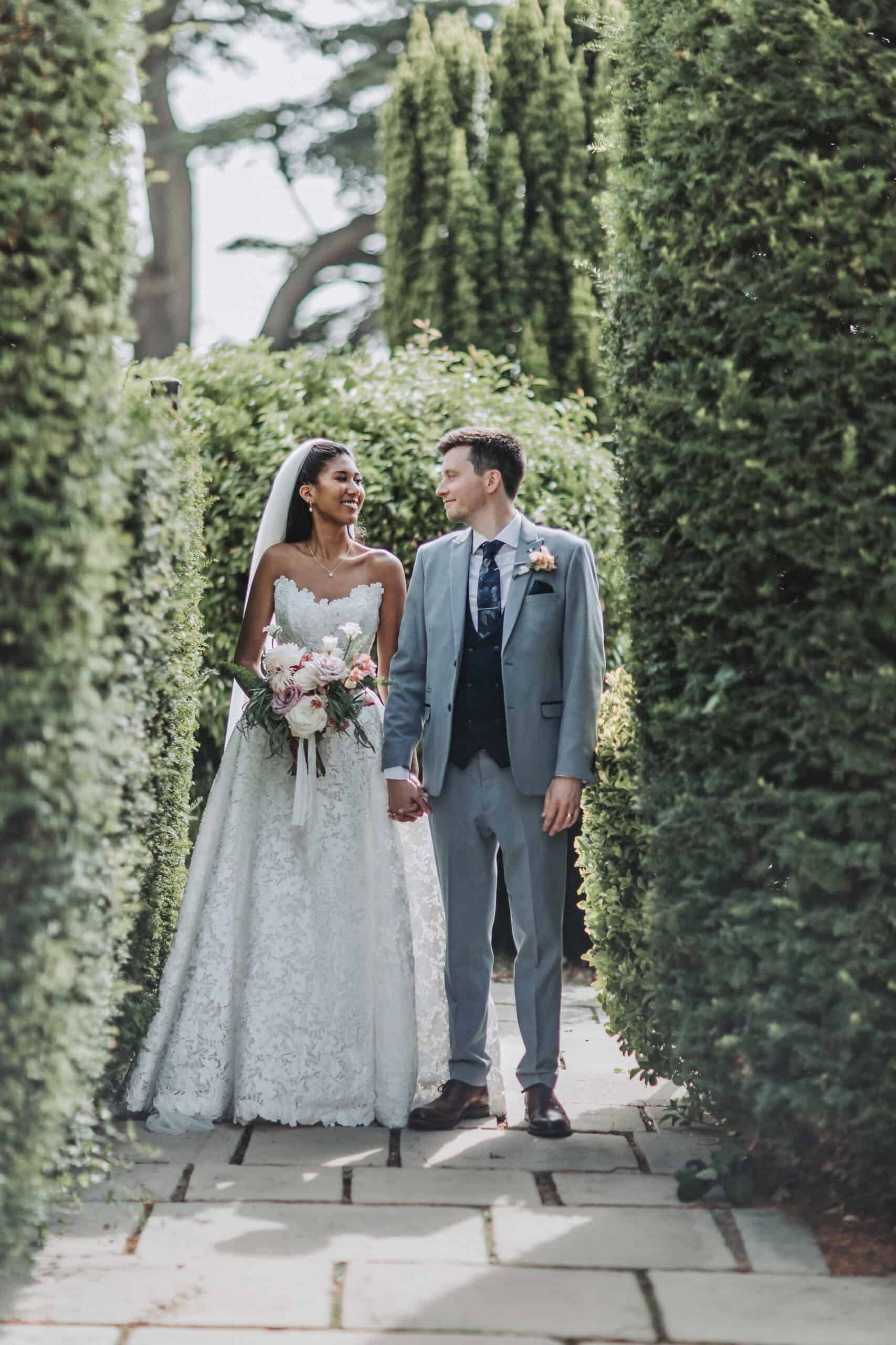 wedding photography packages Bride and groom walking hand in hand at St Michael’s Manor captured by Hertfordshire wedding videographer