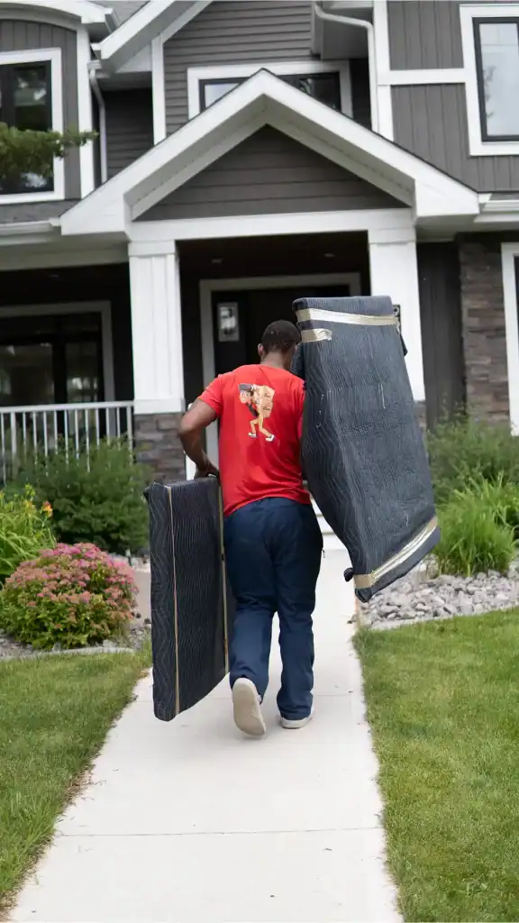 Man carrying large furniture piece to a house during residential move in Edmonton.
