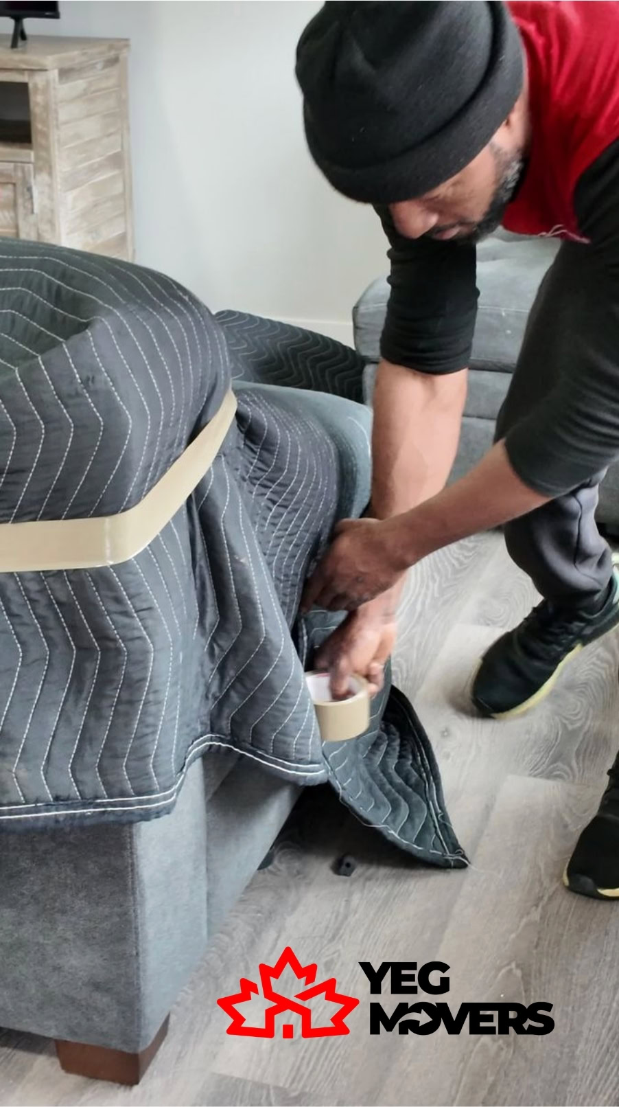 Mover securing furniture with tape during a professional move in Edmonton.