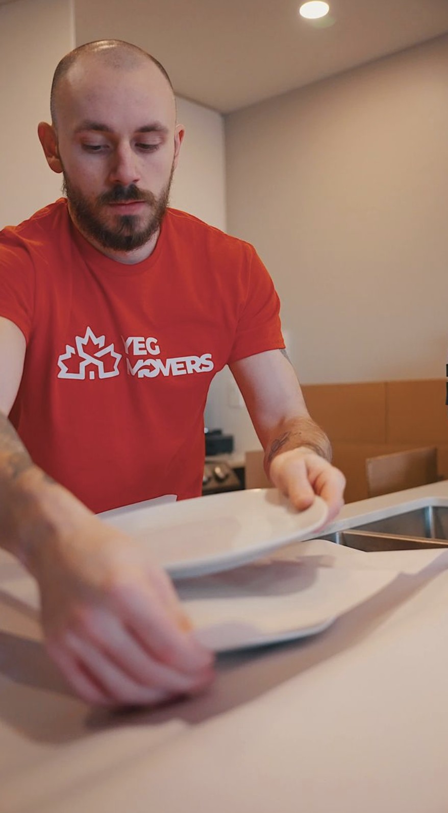 edmonton mover carefully packs kitchen plates with protective wrapping to keep fragile items safe during a residential move