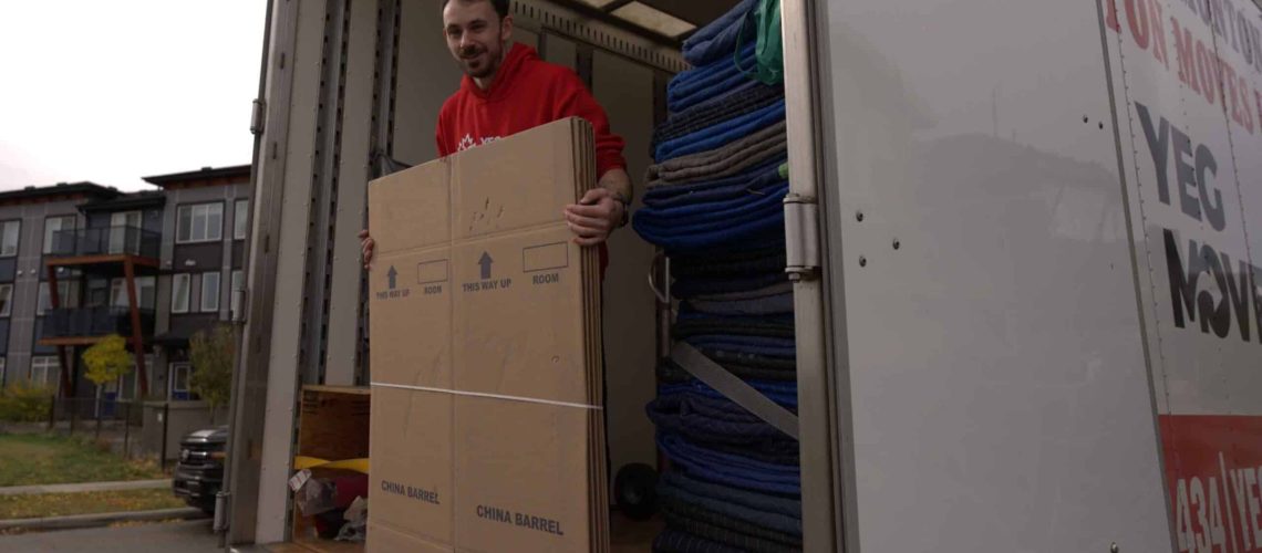 Man loading boxes into a moving truck for efficient packing and transportation.