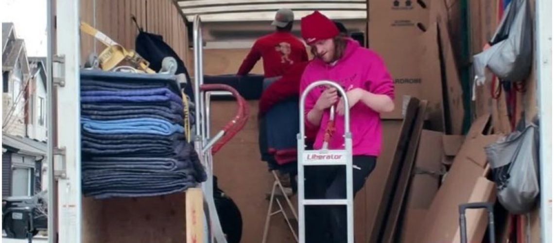 Movers loading furniture and boxes into a moving truck in Edmonton.