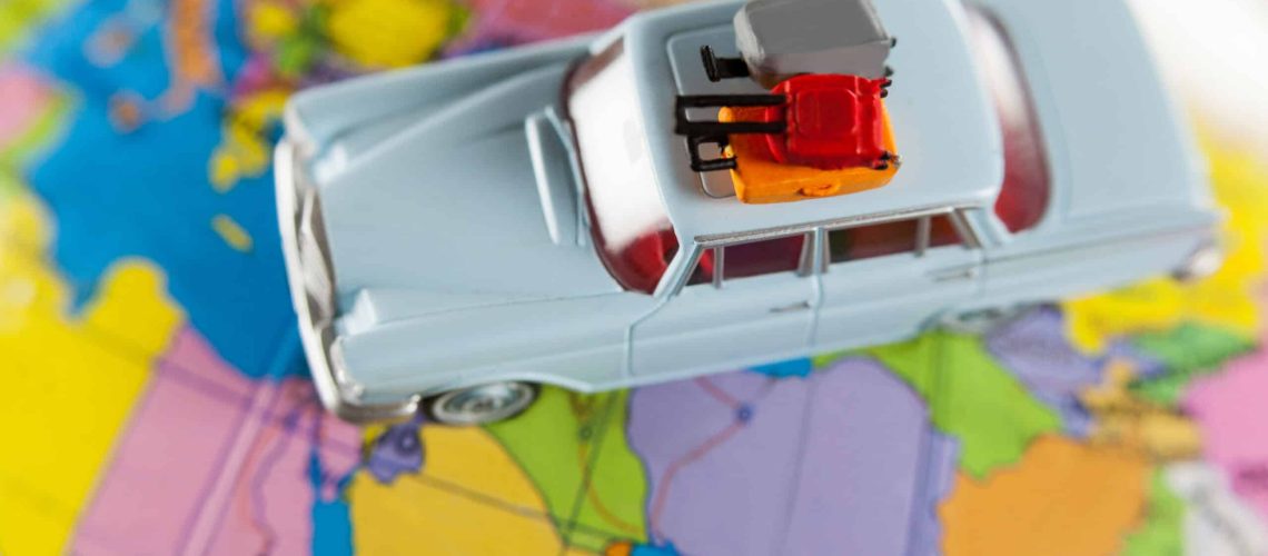 Toy car on a world map representing international move planning.