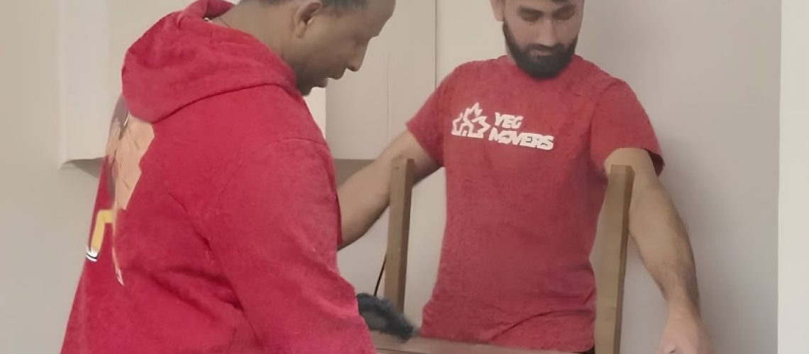 YEG Edmonton Movers team packing furniture in a residential setting.