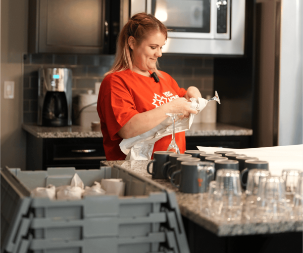 Woman packing dishes in kitchen during moving process in Edmonton.