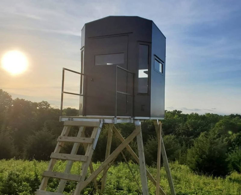 deer stand hunting blind in green field