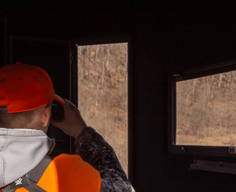 hunter using binoculars in deer stand