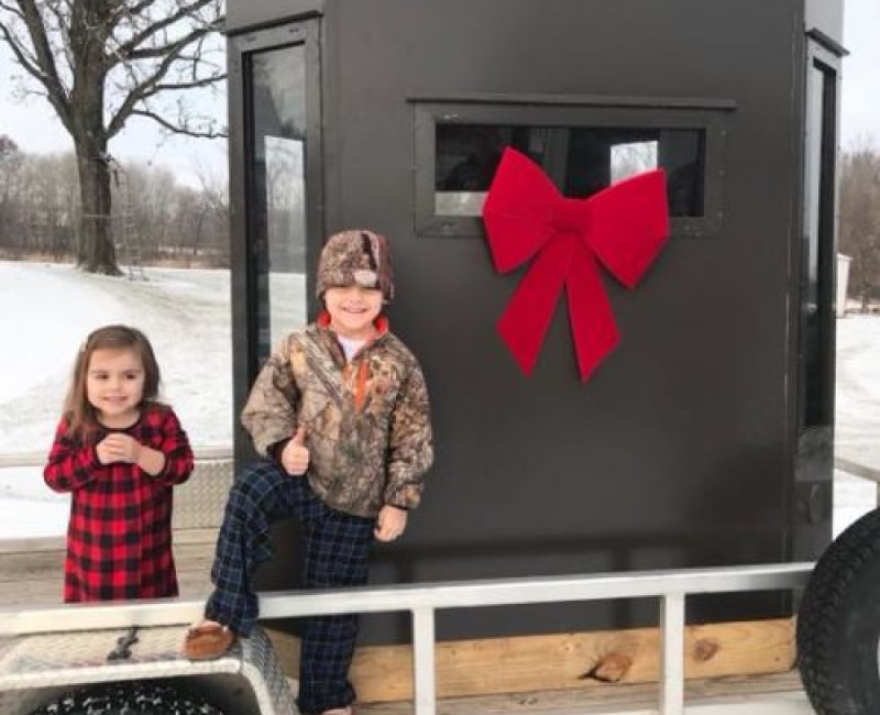 two happy childeren with hunting blind and bow