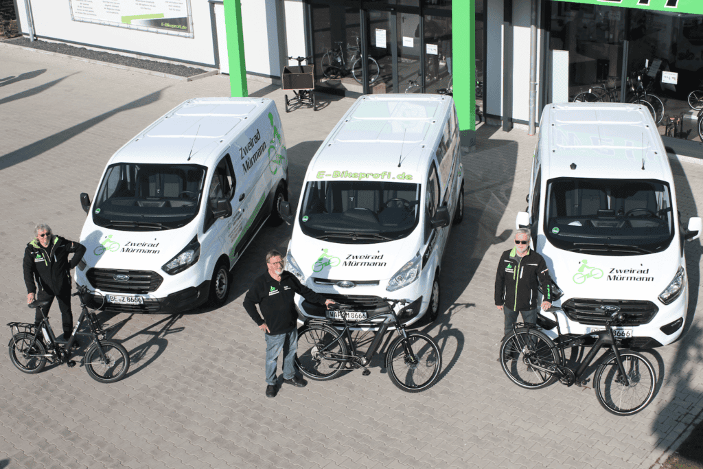 Zweirad Mürmann - E-Bike & Fahrrad Shop Team mit E-Bikes vor Zweirad Mürmann in Drensteinfurt.