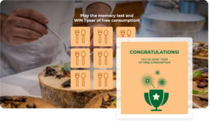 Person spielt ein food-basiertes Memory-Spiel auf Gamification-Software und gewinnt einen Wettbewerb mit Popup „CONGRATULATIONS! YOU'VE WON 1 YEAR OF UNLIMITED CONSUMPTION“, Trophäe und Feuerwerk – Beispiel für erfolgreiche Online-Gewinnspiele.
