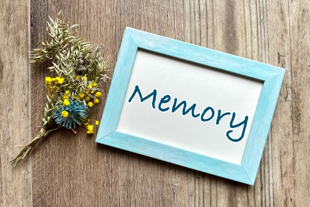「Memory」と書かれた写真立てとドライフラワーのイメージ写真