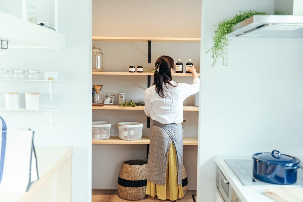 キッチンで日々の家事とセットで片付けを実践する女性の後ろ姿