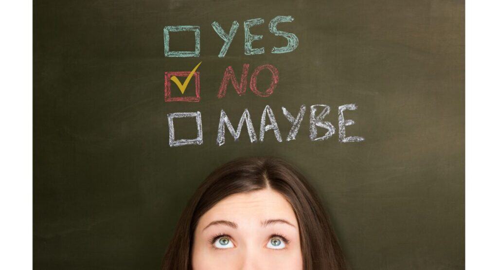 黒板にYES・NO・MAYBEの選択肢と、NOにチェックマークを入れた女性のイメージ写真