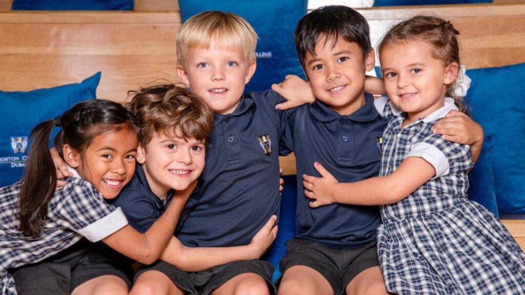 Happy students from Brighton College Dubai smiling together in classroom.
