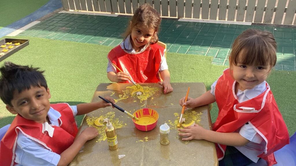 Children painting at Dubai International Academy playground.