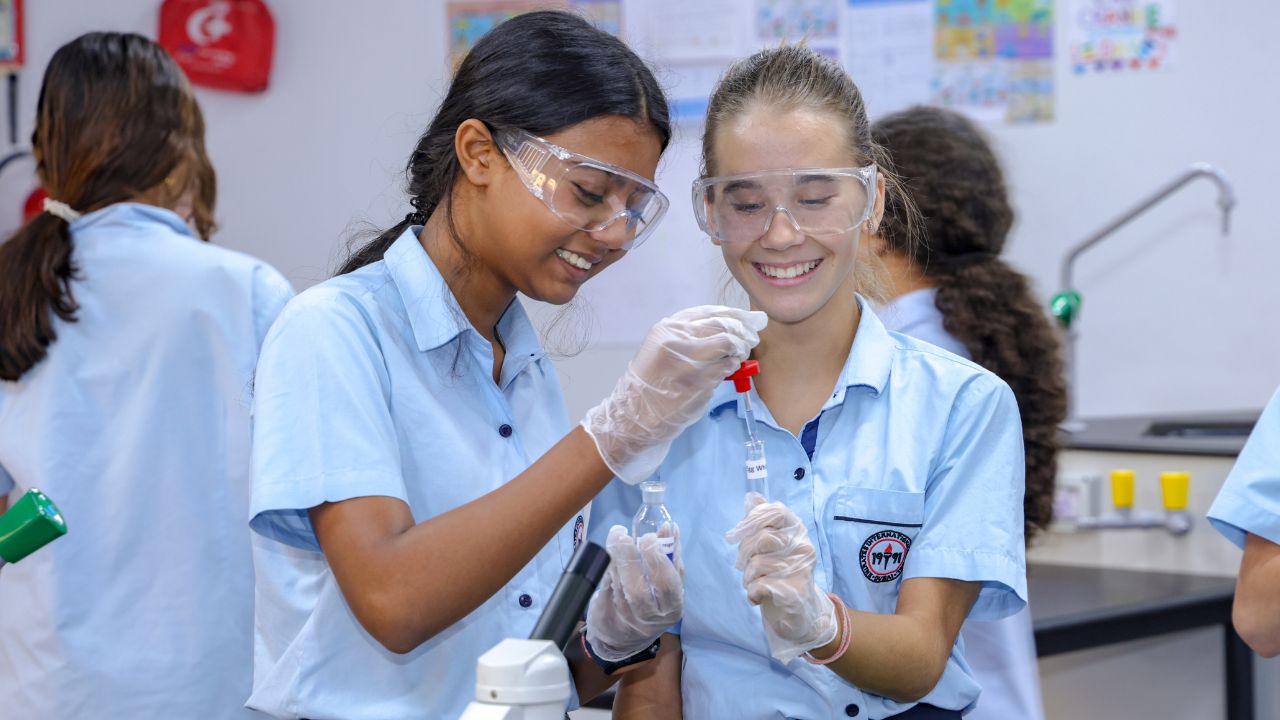 Students performing science experiments in a classroom at Emirates International School - Meadows.