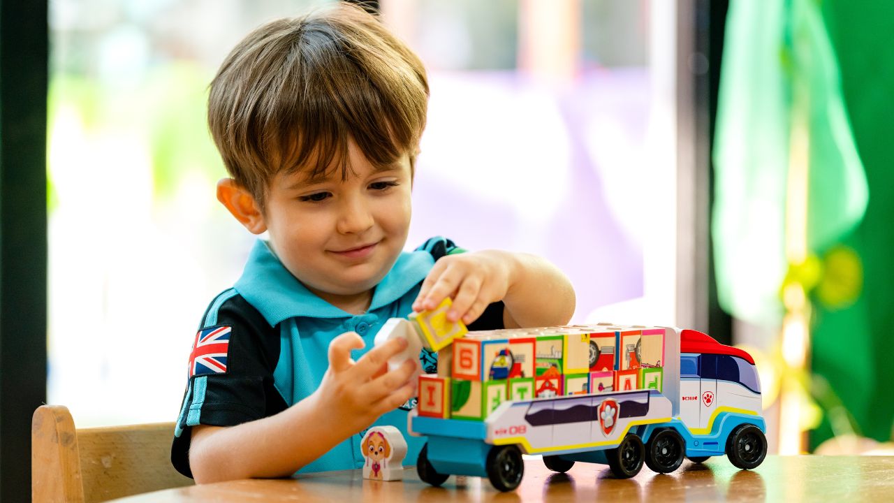 Child playing with colourful toy truck in Dubai.