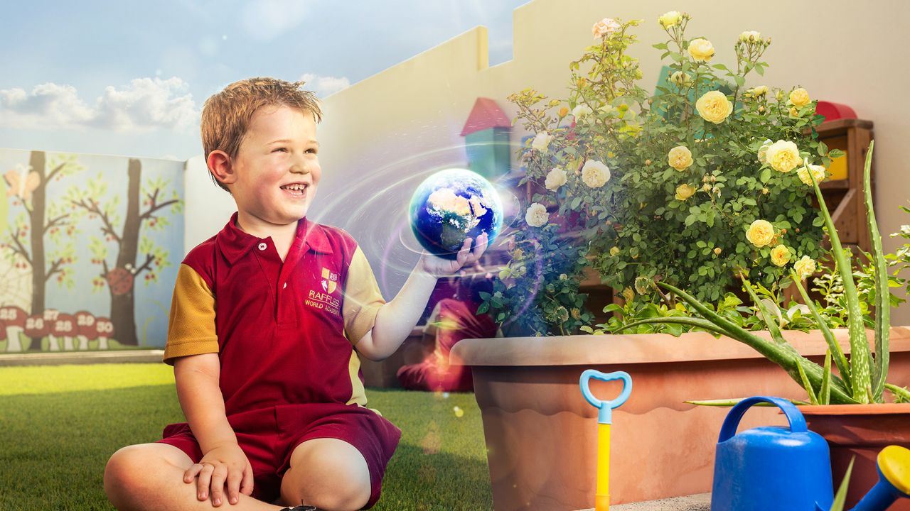 Young boy holding a glowing Earth model outdoors.