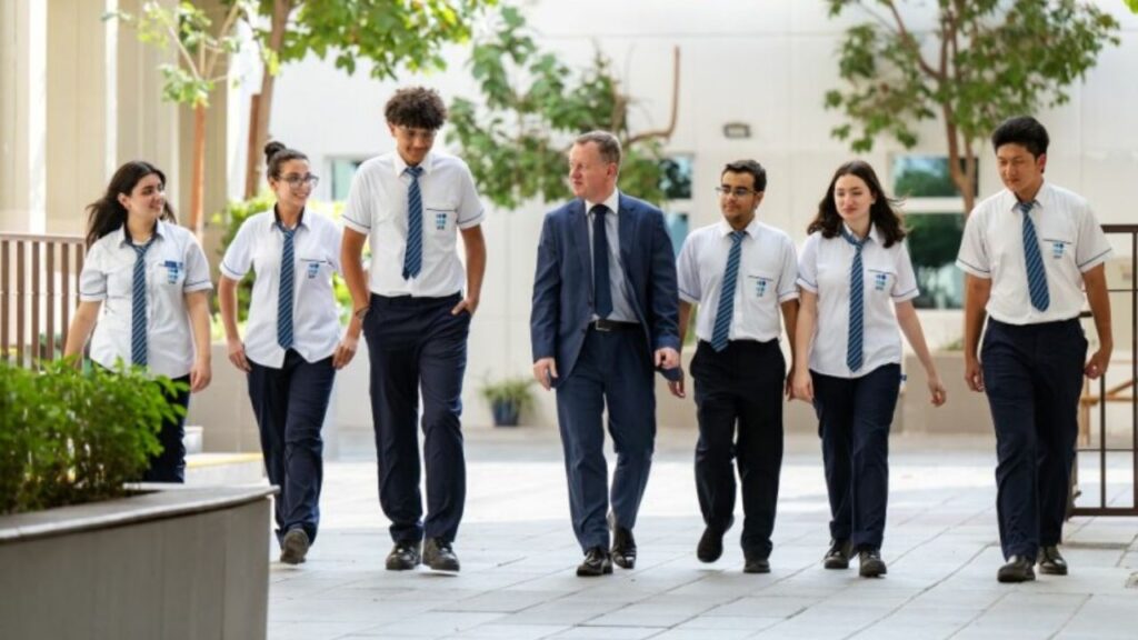 Group of students and teacher walking outdoors at Uptown International School.