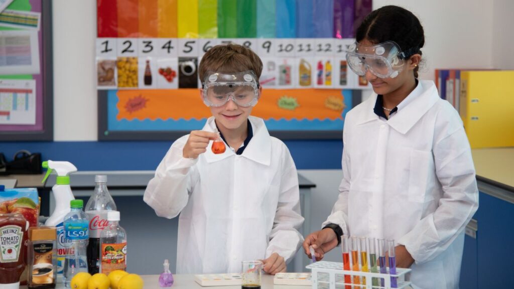 Two children conducting a science experiment in a classroom.