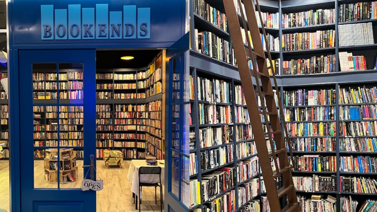 Bookends library with shelves full of books and a ladder for access.